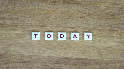 Word "Today" is made up of letters on a wooden background. Design for presentation of business idea, startup, report. Word "Today" is written from letters on table. Video saver with word "Today".