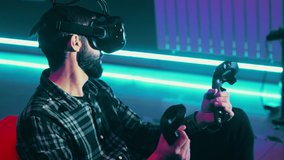 Bearded man playing a Metaverse game using modern virtual reality headset with gamepad, remote controllers, in vr club