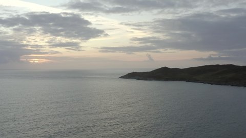 Rising Aerial Shot of a Beautiful Sunset with a Headland in the Foreground