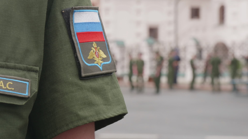 Russian Army Side Arm Badge and Ranking on Soldier During Marching Ceremony. Green Shirt with Russian Flag.