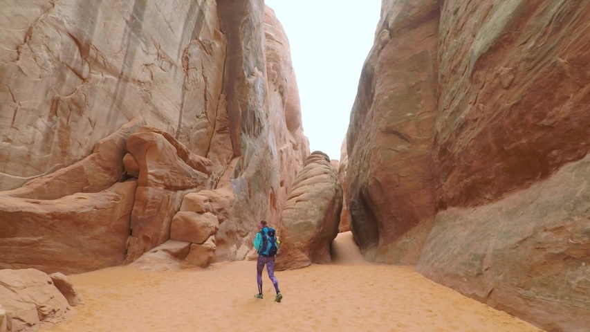 Young woman hiking in Arches National Park. Active vacations in Arches National park.