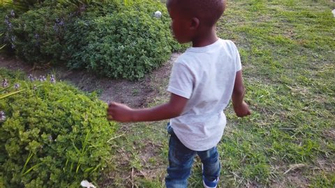 Black child says shhh while playing outside.