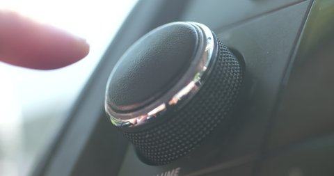Close up, turning down the volume on a car radio
