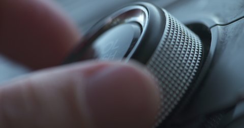 Macro close up, turning up the volume on a car radio
