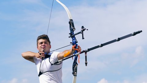 Male archer is shooting after aiming. Shooting with a bow and arrows.