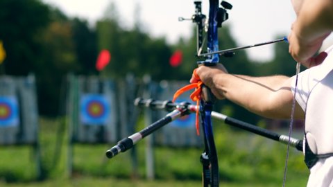 The bow in male hands while preparing and aiming. Shooting with a bow and arrows.