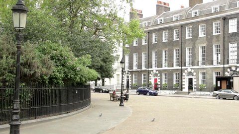London, England - August 2019: A photo shoot in Bedford Square, Bloomsbury. The green park behind the railings to the left and Georgian Architecture to the right.