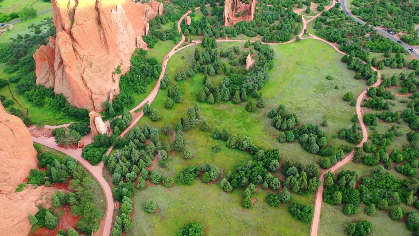 Aerial, tilt up, drone shot, over the Garden of the Gods park, revealing the red mountain formations, on a sunny evening, in Colorado springs, USA