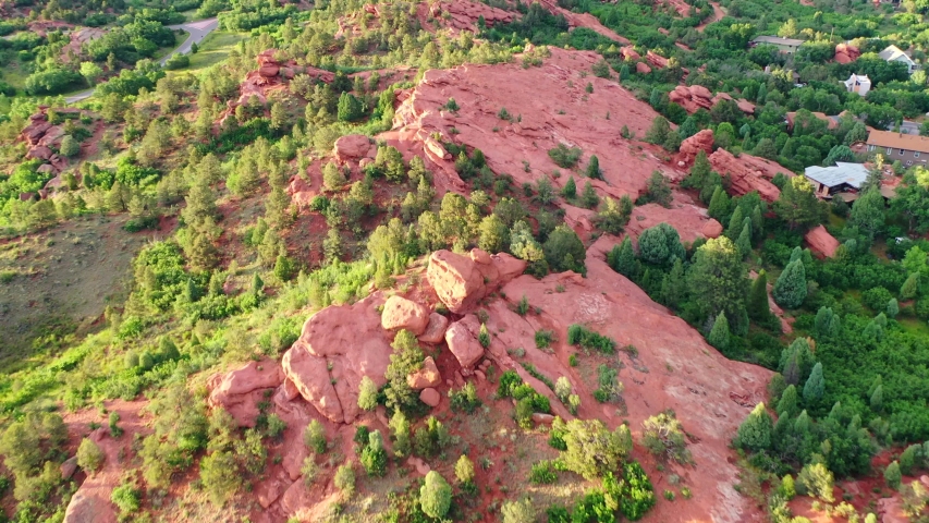Aerial, tilt up, drone shot, towards the red mountain formations, at the Garden of the Gods park, on a sunny evening, in Colorado springs, USA