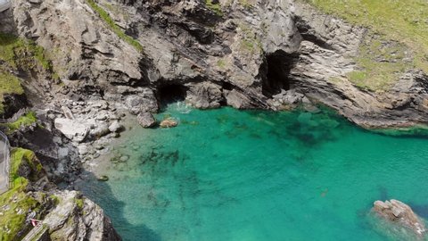 Drone footage of the picturesque shoreline at Tintagel, Cornwall with Merlin's Cave and the tiny Haven Beach