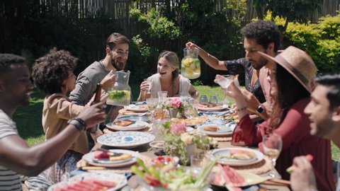 happy friends celebrating garden party lunch having fun chatting sharing healthy food enjoying weekend reunion relaxing on beautiful summer day outdoors 4k