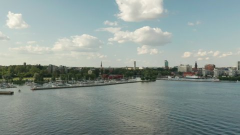 Aerial panning footage of Vasteras city skyline. Waterfront & harbor sunny summer day.