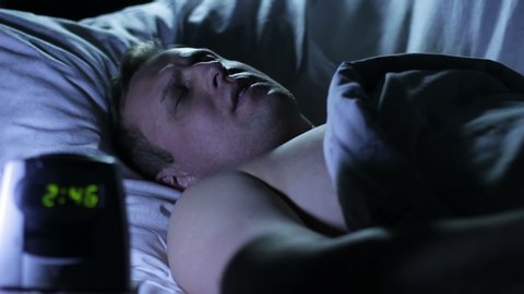 Sleep disorder and nightmare. A man waking up late at night from a nightmare