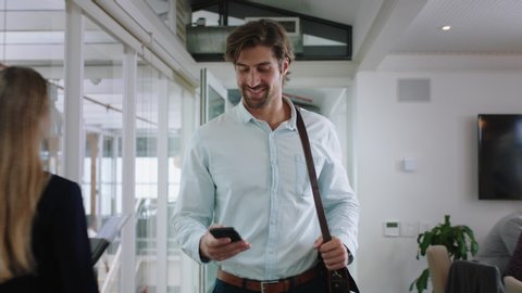 attractive businessman using smartphone walking through office texting sending emails successful male executive checking messages on mobile phone arriving at workplace 4k