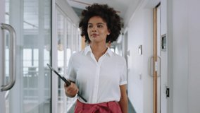 mixed race business woman smiling walking through office holding tablet computer enjoying successful career in corporate workplace 4k - Powered by Shutterstock - Get 15% off with code: PIKWIZARD15