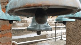 Still close up video of large old wet metal bells in temple in day time.