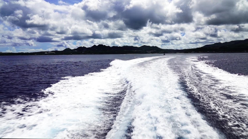 Waves of the sea foam and shallow ripples near the ship.