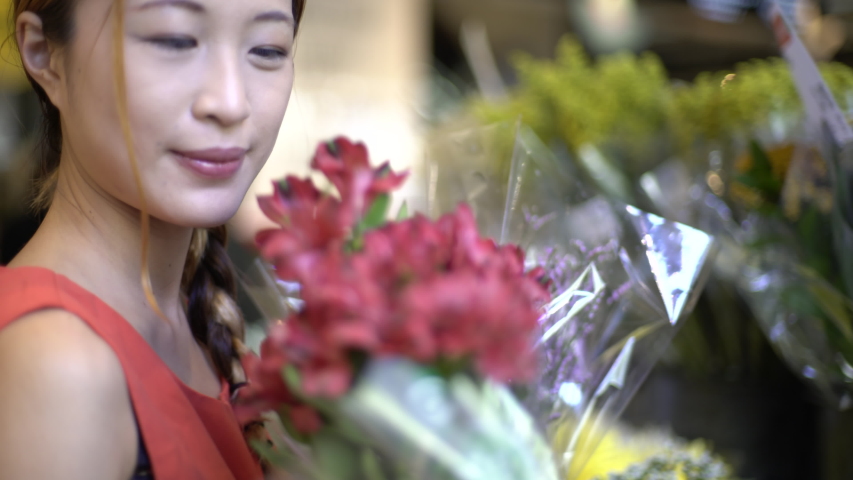 Close-up shot of a young woman buying a flower bouquet in a flower shop | Shutterstock HD Video #1034456807