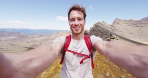 Selfie Video - Smiling young man backpacker taking video selfportrait in beautiful mountains. Healthy hiking man enjoying at Tongariro Alpine Crossing landscape, Tongariro National Park, New Zealand
