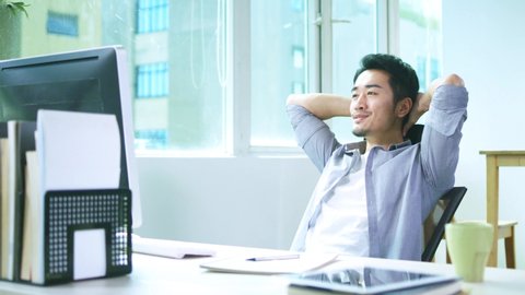 young asian business man working in office using desktop computer
