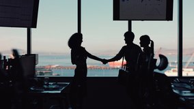 silhouette business people shaking hands consultant greeting international clients with handshake planning partnership deal female executive meeting shareholders in corporate office at sunset - Powered by Shutterstock - Get 15% off with code: PIKWIZARD15