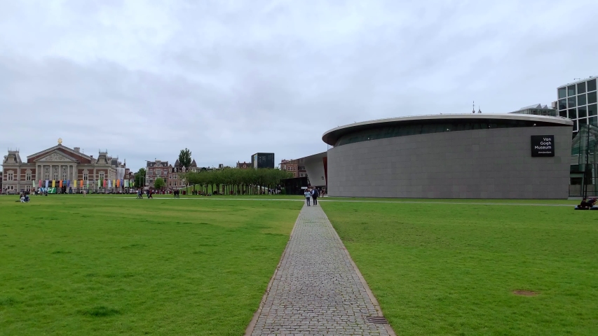 Motion lapse of people walking, hanging out at museum quarter in Amsterdam. It is a summer day. Camera moves around.