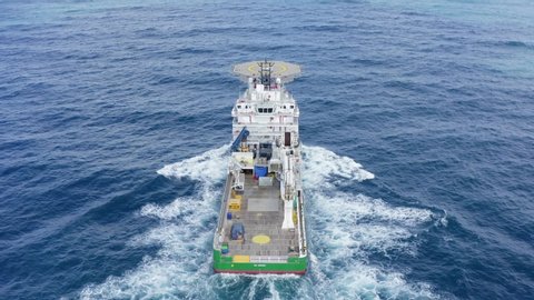 Mediterranean Sea -  July 13, 2019: Green Offshore supply ship with Helipad at sea, Aerial follow footage.