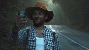 A travel blogger records videos for a blog. Walking along the road, holding a smartphone in his hands. Makes a movie for vlog. Travel popular trip.