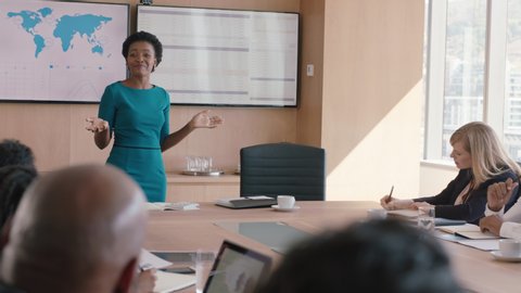 Black business woman presenting financial data on tv screen sharing project with shareholders team leader briefing colleagues discussing company growth ideas in office boardroom presentation