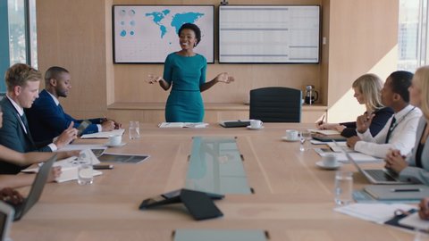 Black business woman presenting financial data on tv screen sharing project with shareholders team leader briefing colleagues discussing company growth ideas in office boardroom presentation