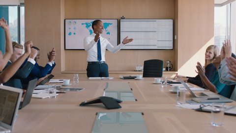 Black businessman presenting successful solution to shareholders celebrating with applause congratulating executive for growth in sales clapping hands in office boardroom meeting