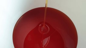 Honey pourin in white bowl. Close-up. Healthy organic Thick honey dipping, closeup. 4K UHD video footage.