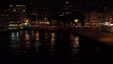 night time istanbul bosphorus shot with drone including ortakoy mosque and bosphorus bridge and boats and crowd