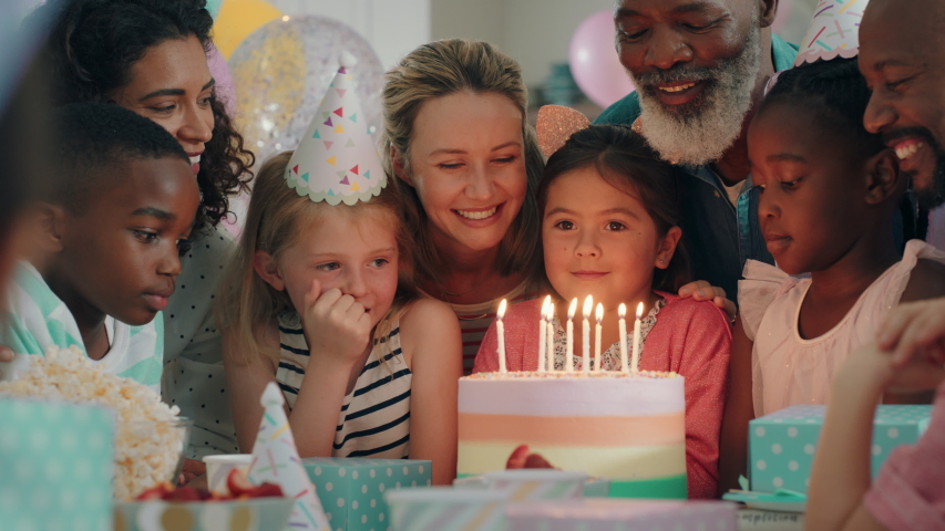 happy birthday girl blowing candles on cake making wish celebrating party with multiracial friends children having fun celebration at home 4k footage Royalty-Free Stock Footage #1034485487