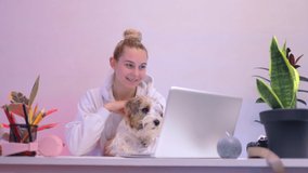 young caucasian girl play with jack russell terrier at table watch video on laptop work study chill relax room home loft studio office 5g social shopping think funny