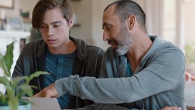 father and son using laptop computer dad helping teenage boy with homework at home teaching problem solving parent supporting education 4k - Powered by Shutterstock - Get 15% off with code: PIKWIZARD15