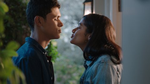 funny teen couple kiss nervous teenage girl kissing boyfriend on chin enjoying romantic evening date outside home 4k footage