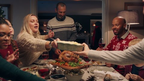 family christmas dinner man cutting turkey serving delicious meal at festive celebration people sitting at table enjoying delicious feast celebrating holiday at home 4k footage