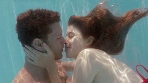 romantic couple kissing underwater in swimming pool seductive woman making out with young man floating in water with bubbles sharing intimate kiss summer romance 4k