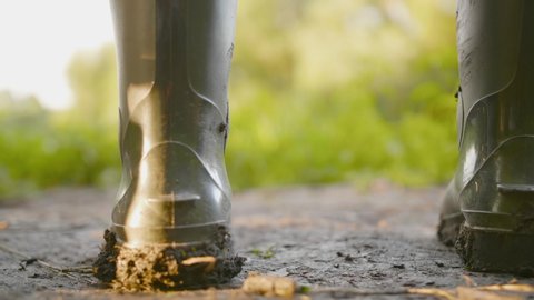 Close up rubber rain boot with mud work on dirty place