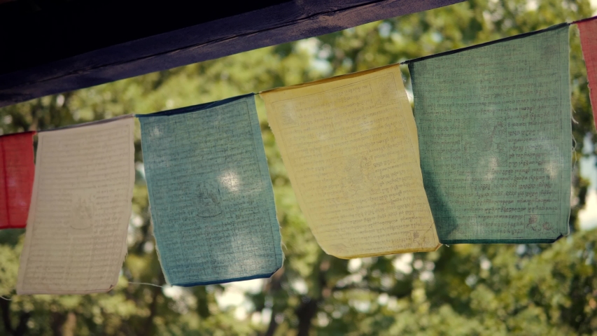 Multicolored Flags Fluttering On Winds Blow In Buddhist House.Buddhist Prayer Flags Swaying In The Wind. Spirituality Colorful Tibetan Prayer Flags Flying In Wind On Temple.Traditional Himalaya Simbol