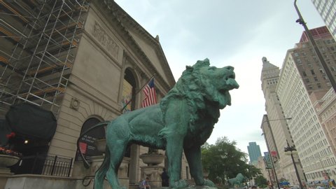 Chicago , Illinois / United States - 06 27 2019: The Art Institute of Chicago, Illinois, United States, Usa. The lion sculpture in front of the museum, American flag, tourist attraction, in downtown t