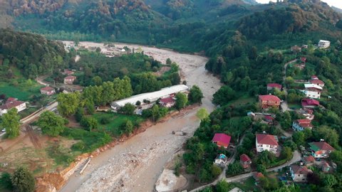 Aerial drone view:fly over a town,fields and flooded rural houses surrounded by forest and mountains. The place of the disaster in the city of Duzce, Turkey