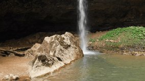 Aerial view panoramic view of a waterfall in a summer forest. Water falls from a cliff. Landscape travel video without people