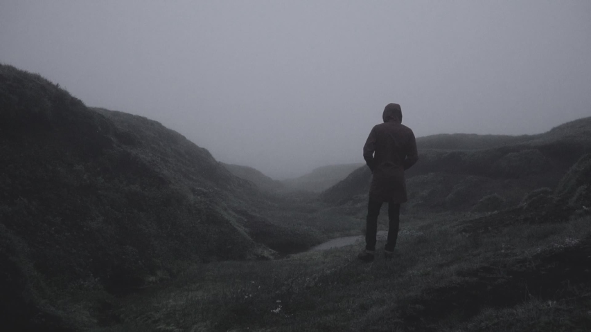 Silhouette in abandoned icelandic canyon in a foggy, moody, dramatic landscape. SlowMo and regulari speed of man