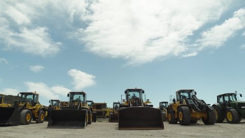 Bulldozers and Loaders Parked By Construction Location, Armada of Heavy Machines Wide Shot