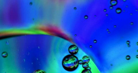Color Drops Floating in oil and Water over a colorful underground