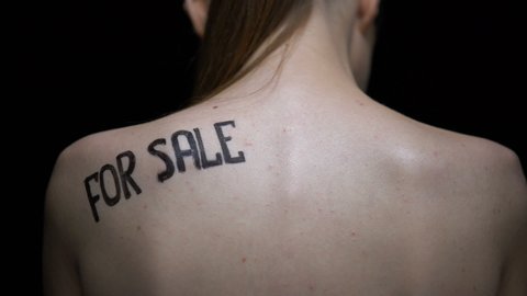 Frightened naked woman wiping for sale phrase from shoulder, human trafficking