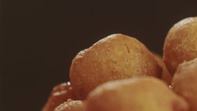 Close-up on Turkish donuts Lokma poured with thick honey. Slow Motion video. Ramadan