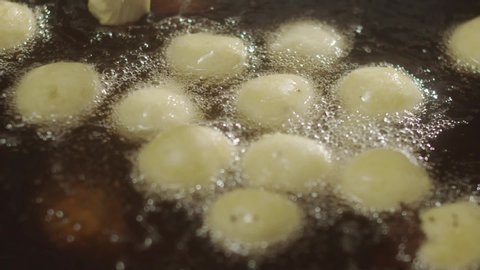 Close-up of Turkish cooking donuts Lokma with deep-fried. Slow Motion video. Ramadan